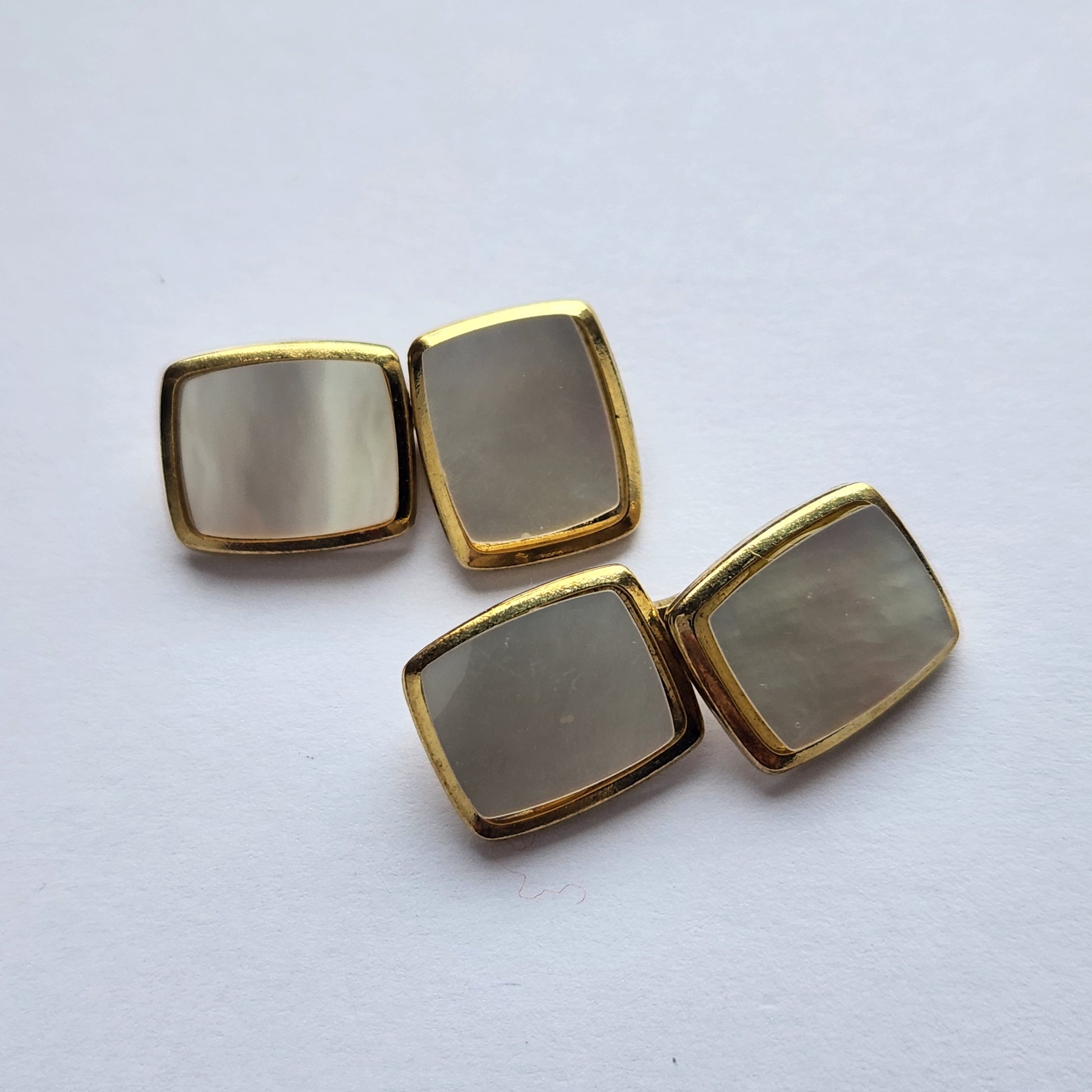 Elegant gold-tone cufflinks with pearl inlay from above