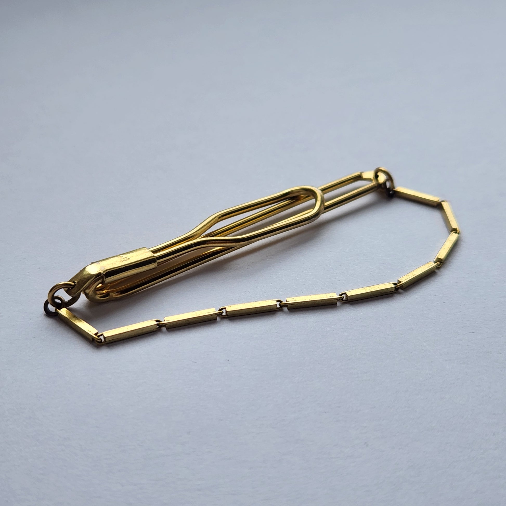 Close-up of a vintage gold-tone tie clip by TEKA.